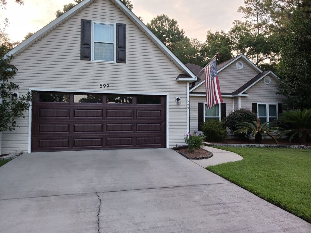 Front view of a house with a garage, US flag, and landscaped yard at 599.