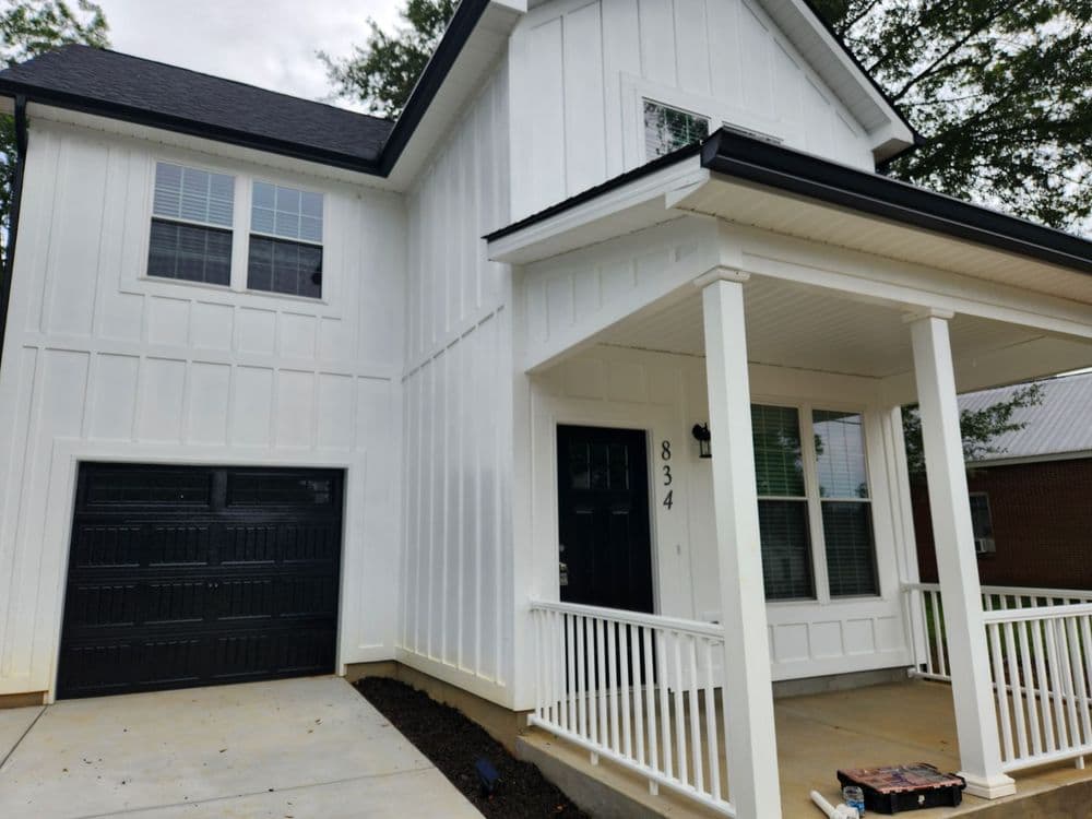 Newly built white home with black accents, garage, and porch at 834 address.